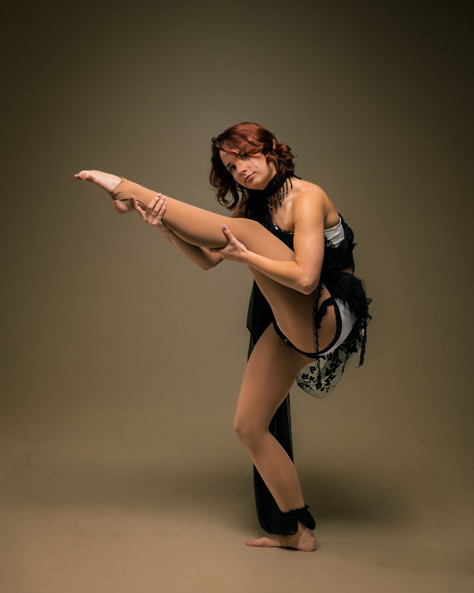 Soloist in black corset, leg held high