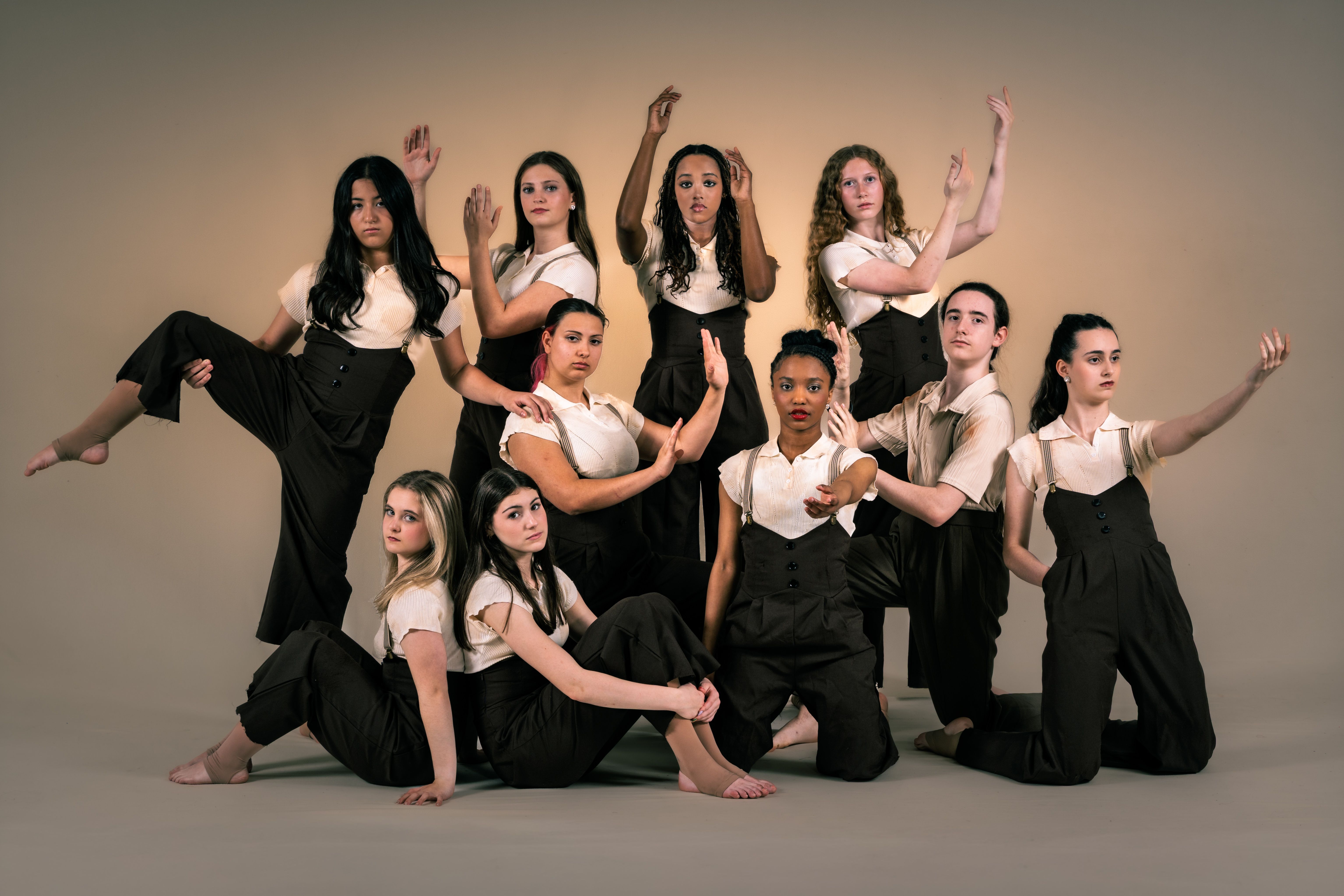 Ensemble in suspenders, hands raised